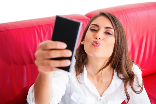 Jeune femme rondeur tout en prenant selfie sur canapé Images De Stock Libres De Droits