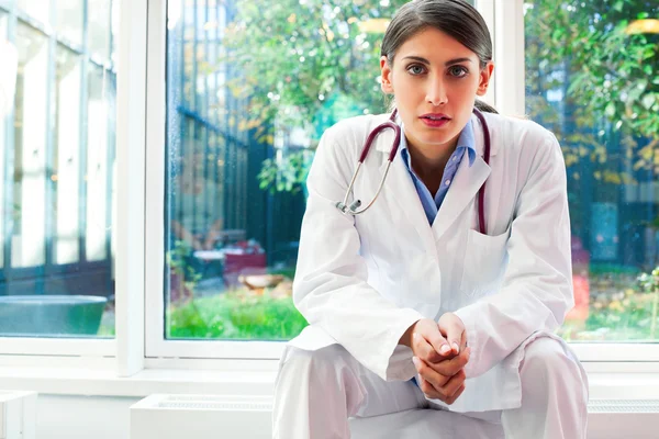 Portrait of serious female doctor with hands clasped — Stock Photo, Image