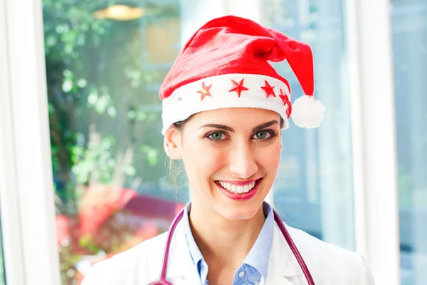 Felice medico donna indossando cappello di Babbo Natale Immagine Stock