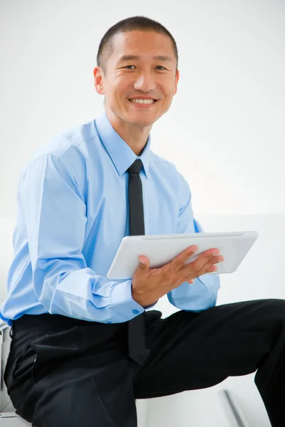 Primer plano del hombre de negocios sonriente sentado escaleras sosteniendo t digital —  Fotos de Stock