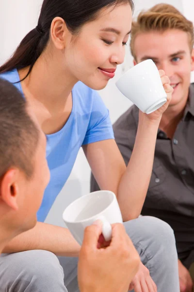 Aziatische jonge vrouw drinken koffie met haar vrienden — Stockfoto