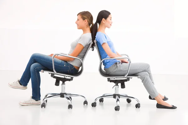 Two businesswoman sitting in chairs to back — Stock Photo, Image