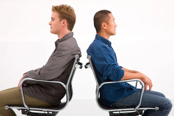 Два бизнесмена сидят в креслах к спине — стоковое фото