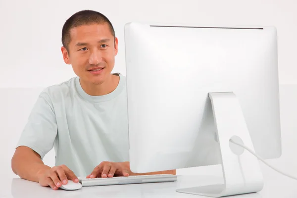Heureux jeune homme utilisant l'ordinateur — Photo