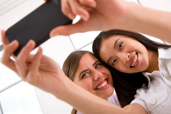 Duas jovens sorridentes tomando auto retrato — Fotografia de Stock