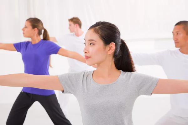 Mulher desportiva esticando as mãos aula de ioga no estúdio de fitness — Fotografia de Stock