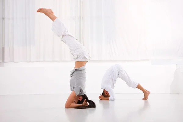 Hombre y mujer practicando yoga en gimnasio — Foto de Stock