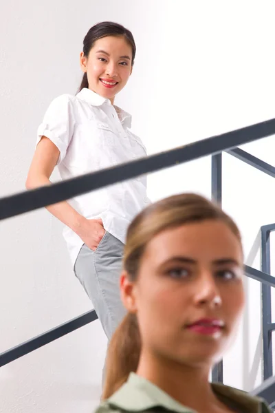 Smiling asian young woman standing staircase — Stock Photo, Image