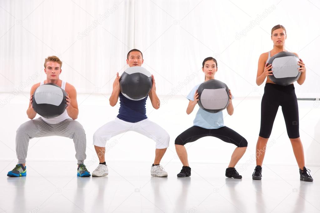Diverse group of people exercising with pilates in gym Stock Photo by