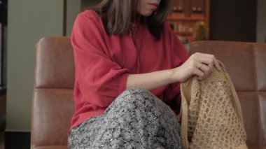 Genç Asyalı kadın kafeteryada sosyal medya için akıllı telefon kullanıyor..