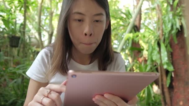 若いですアジアの女性使用して彼女のタブレットコンピュータでコーヒーショップ — ストック動画