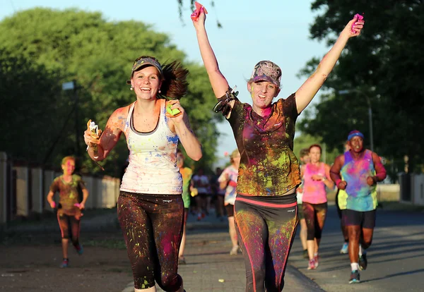 Chearful corriendo chicas jóvenes cubiertas con pintura en polvo — Foto de Stock