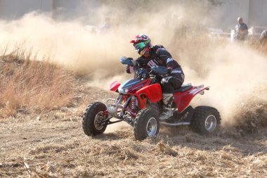 Quad Bike kicking up trail of dust on sand track during rally ra