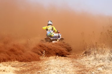 Quad Bike kicking up trail of dust on sand track during rally ra