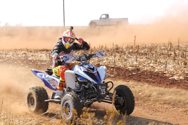 Quad Bike kicking up trail of dust on sand track during rally ra — Stockfoto