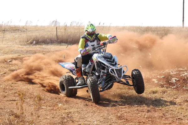 Quad Bike kicking up trail of dust on sand track during rally ra — Stockfoto