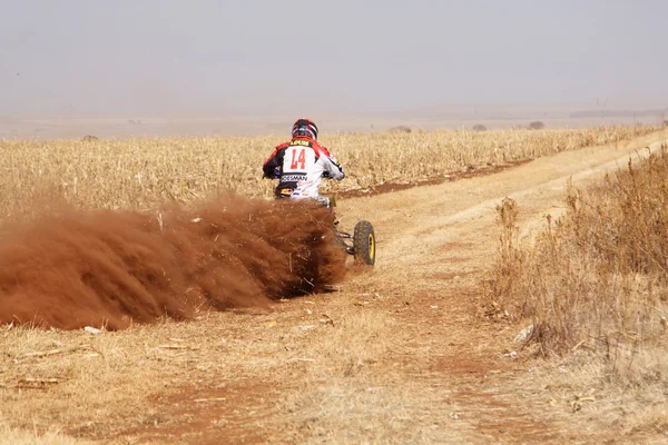 Quad Bike kicking up trail of dust on sand track during rally ra — Stok fotoğraf