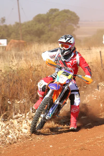 Motorbike kicking up trail of dust on sand track during rally ra — 스톡 사진