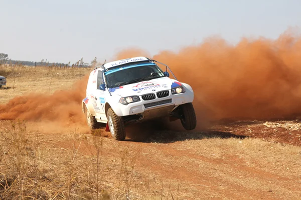 Drifting witte BMW rally auto schoppen stof op zijn beurt. — Stockfoto