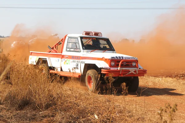 Drifting white Toyota Landcruiser truck kicking up dust on turn — Stock Photo, Image