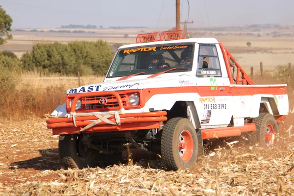 Camión Toyota Landcruiser blanco a la deriva levantando polvo a su vez —  Fotos de Stock