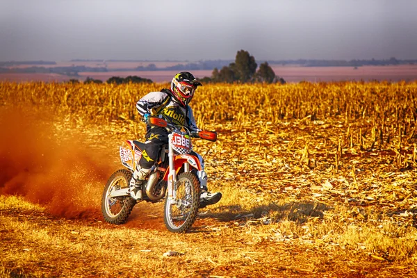 HD - Motorbike kicking up trail of dust on sand track during ral — Stock Photo, Image