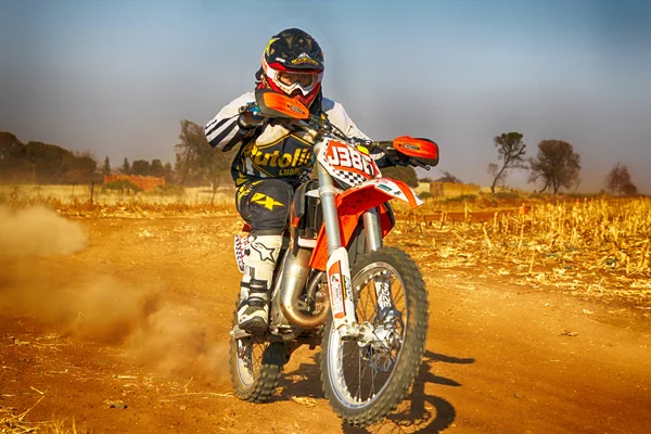 HD - Junior Motorbike kicking up trail of dust on sand track dur — Stock Photo, Image