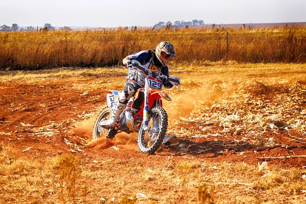 HD - Motorbike kicking up trail of dust on sand track during ral — Stock Photo, Image