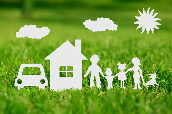 Paper cut of family with house and car on green grass — Stock Photo, Image