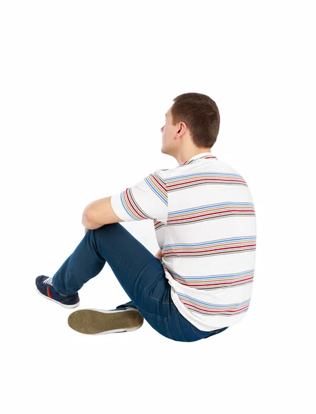 Widok z pozycji siedzącej przystojny mężczyzna w t-shirt i dżinsy, patrząc z tyłu — Zdjęcie stockowe