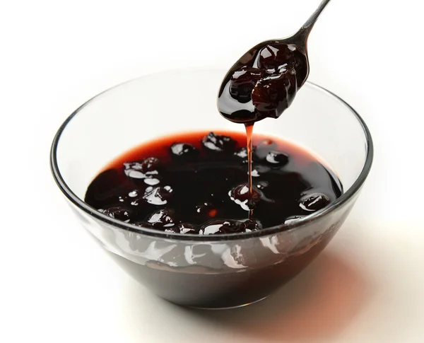 Sweet cherry jam in the transparent glass bowl and tea spoon — Stock Photo, Image