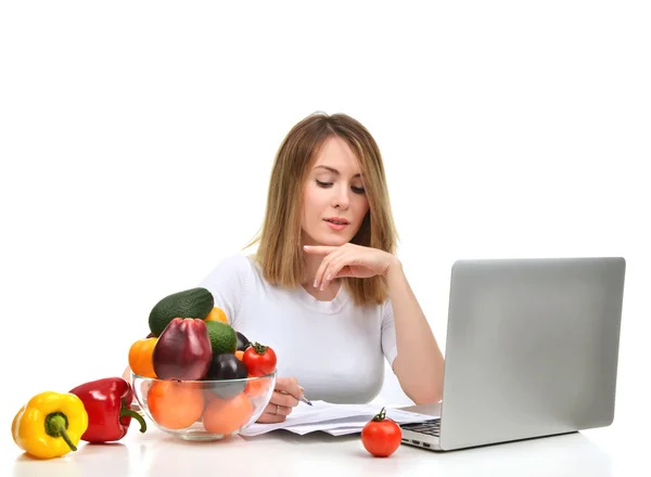 Nutricionista mulher confiante trabalhando na mesa com frutas frescas a — Fotografia de Stock