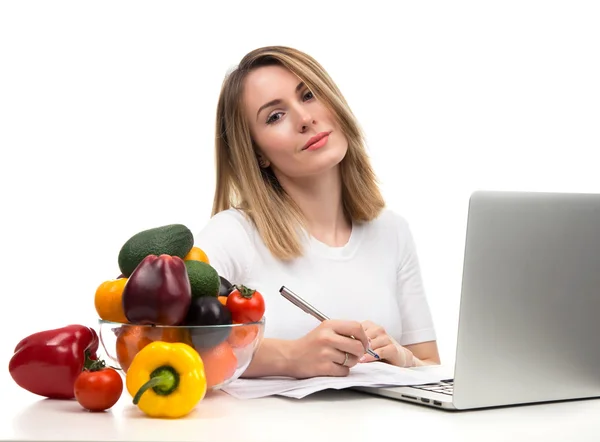 Säker nutritionist kvinna som arbetar på skrivbord med färsk frukt en — Stockfoto