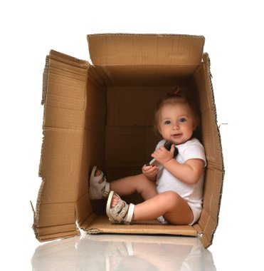 Mutlu küçük çocuk bebek kız Fu sahip bir karton kutunun içinde gizleme