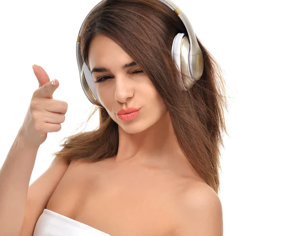 Brunette woman listening and enjoying music in gold headphones — Stock Photo, Image