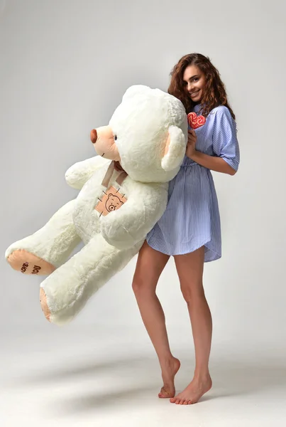 Young beautiful girl with big teddy bear soft toy happy smiling — Stock Photo, Image