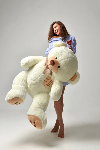 Young beautiful girl with big teddy bear soft toy happy smiling — Stock Photo, Image