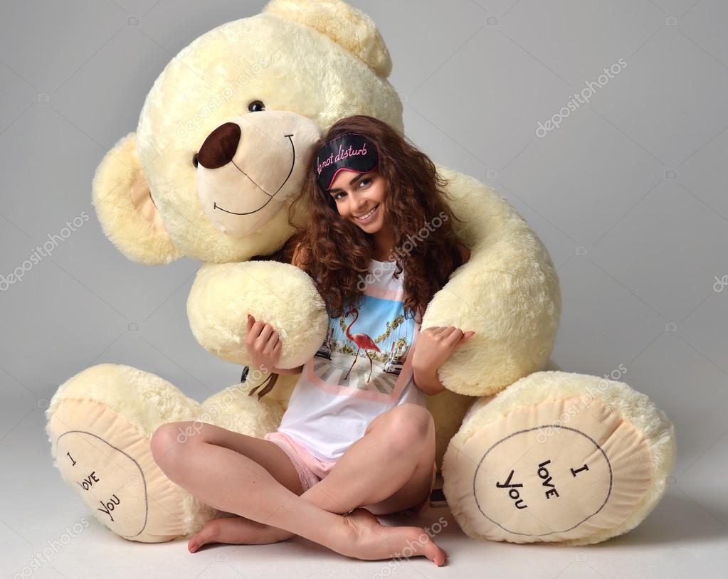 Young beautiful girl hugging big teddy bear soft toy happy smili ...