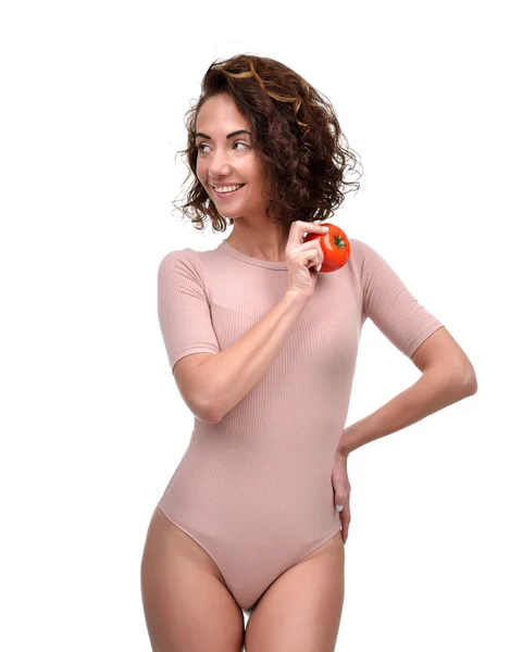 Pretty curly woman with red tomato in hand smiling and looking a — Stock Photo, Image