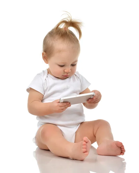 Criança feliz bebê criança sentada sorrindo e brincando com celular — Fotografia de Stock