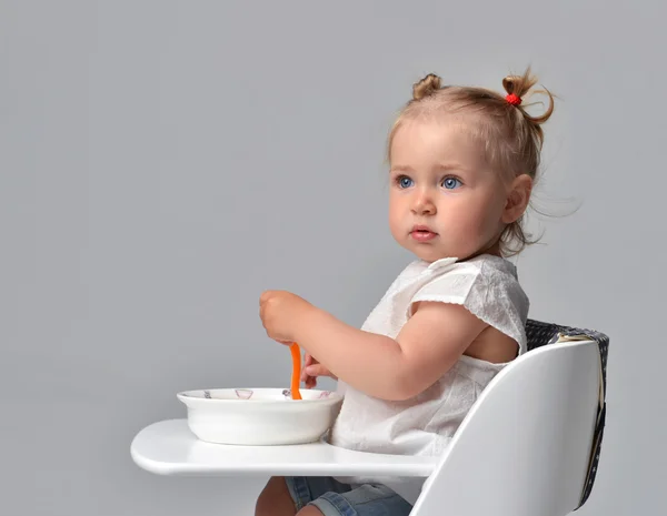 Child toddler kid sitting with plate and spoon on white baby cha — Stock Photo, Image