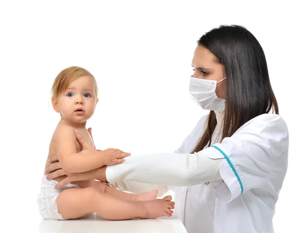 Pediatra médico mulher em máscara médica segurando em seus braços ch — Fotografia de Stock