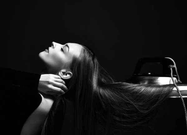 Retrato preto e branco da bela mulher posando com os olhos fechados e seu longo cabelo liso sedoso sob ferro a bordo — Fotografia de Stock