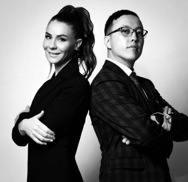 Genç pozitif çift, erkek ve kadın iş ortakları resmi giysiler içinde sırt sırta dururlar.