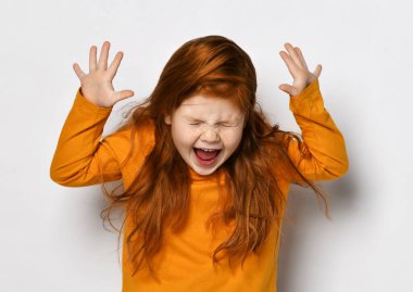 Sarı uzun kollu çilli neşeli kızıl saçlı kız çılgın ve heyecanlı, gözleri kapalı ve ağzı açık.