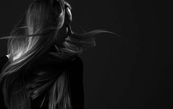 Black and white portrait of young happy woman fairy with healthy strong long flying in the wind hair looking aside Stock Picture