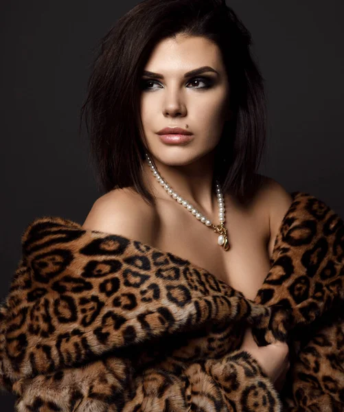 Porträtt av ung ganska sexig brunett kvinna modell i leopard päls med nakna axlar tittar åt sidan — Stockfoto