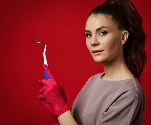 Lekarz ginekolog kobieta w lateksowych rękawiczkach i jednolitego trzymać Transobturator procy, aby ułatwić łatwe zaangażowanie igły — Zdjęcie stockowe