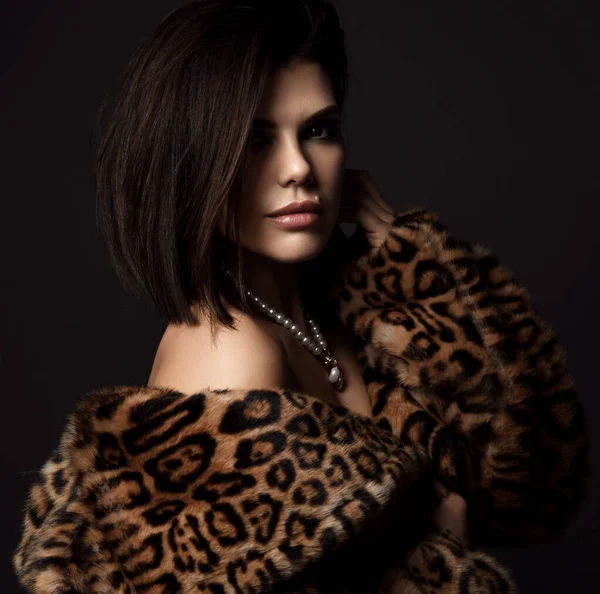 Porträtt av ung rik sexig brunett kvinna i leopard päls jacka med nakna axlar med dyra smycken — Stockfoto