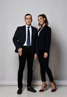 Resmi takım elbiseli genç iş adamları ve kadın iş arkadaşları ayakta duruyor. Tam büyüme portresi.